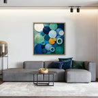Blue Textured Circles Canvas Art – square blue and teal geometric abstract print in a gold floating frame in a living room with charcoal accents
