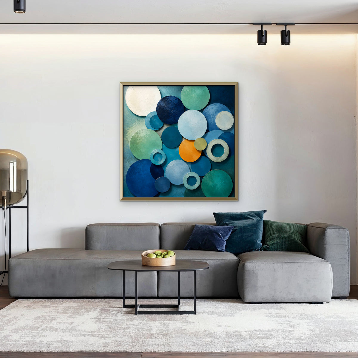 Blue Textured Circles Canvas Art – square blue and teal geometric abstract print in a gold floating frame in a living room with charcoal accents