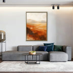 Rust Hills at Dusk Canvas Art – vertical rust and ochre abstract landscape print in a gold floating frame in a living room with charcoal accents